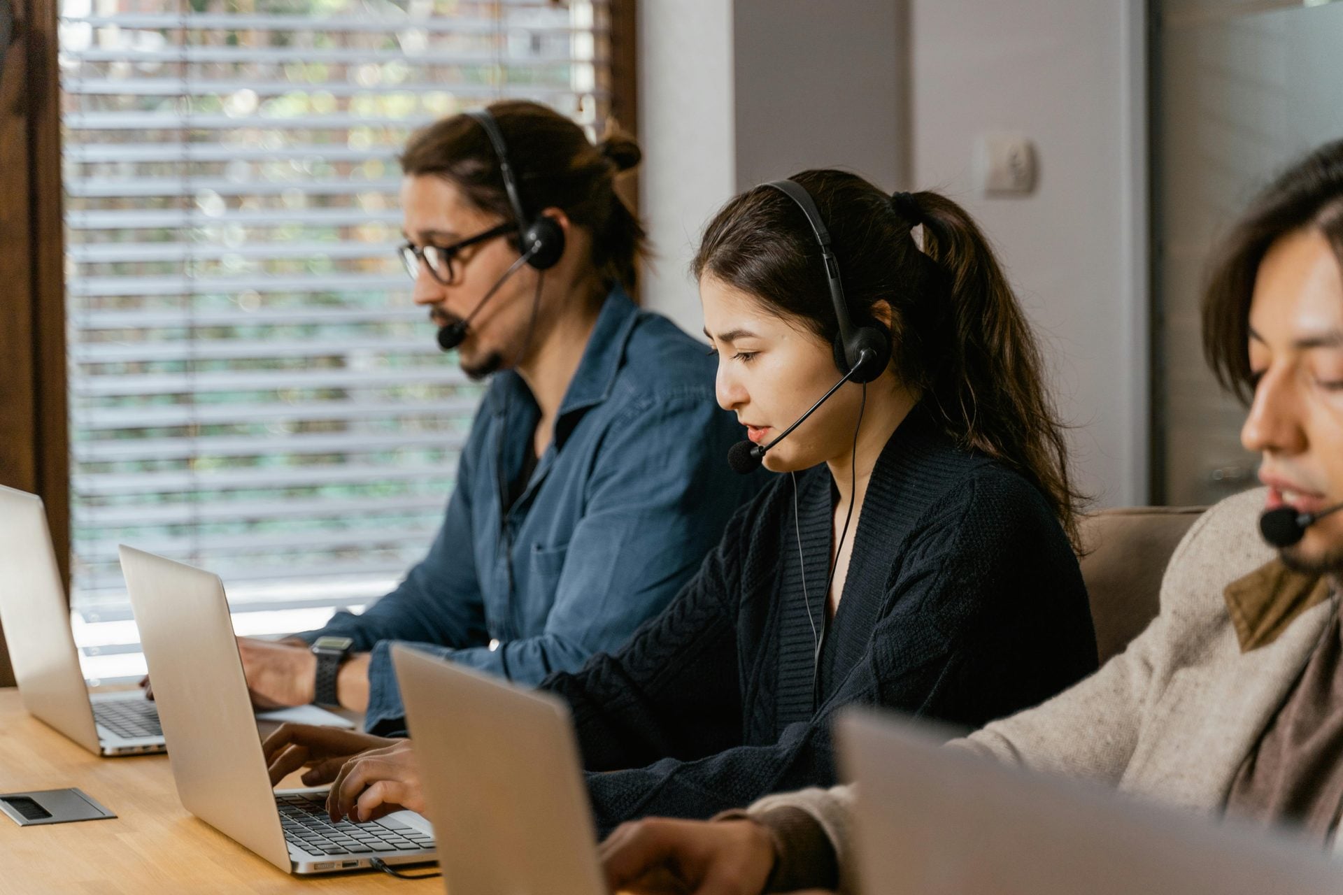Equipo de asistencia al viajero atendiendo llamadas con auriculares